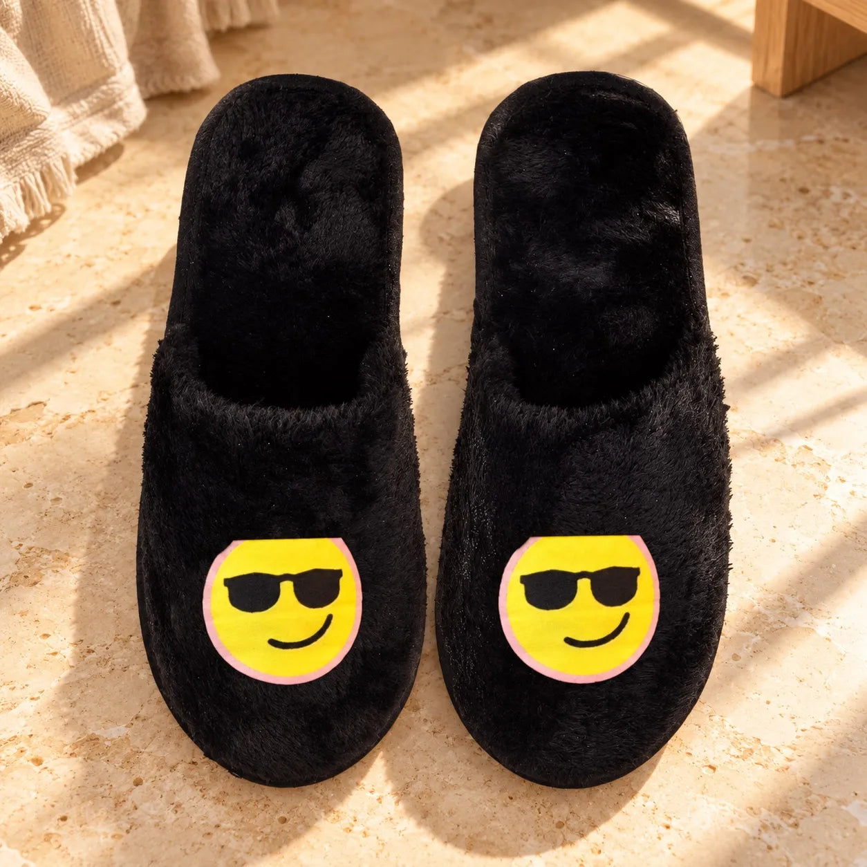 Black TravelKhushi fur slippers with Cool stickers on a warm stone floor